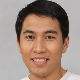 Joyful asian young-adult male with short  brown hair and brown eyes