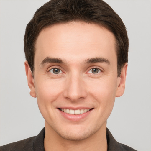 Joyful white young-adult male with short  brown hair and grey eyes