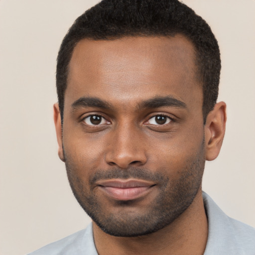 Joyful black young-adult male with short  brown hair and brown eyes