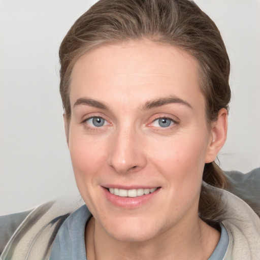 Joyful white young-adult female with short  brown hair and grey eyes