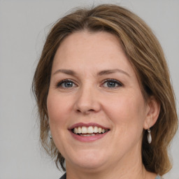 Joyful white adult female with medium  brown hair and grey eyes