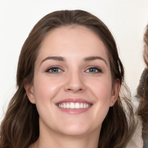 Joyful white young-adult female with long  brown hair and blue eyes