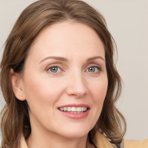 Joyful white young-adult female with medium  brown hair and blue eyes