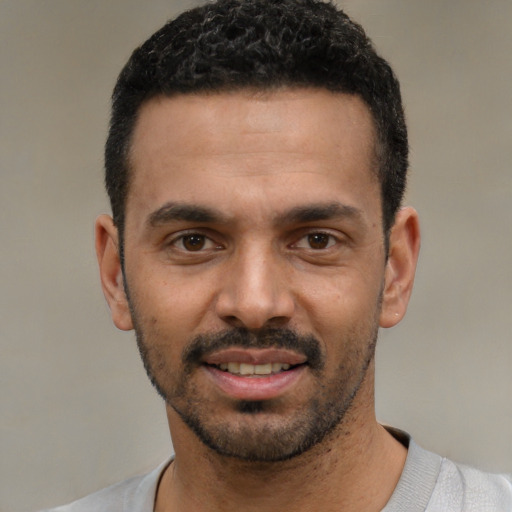 Joyful white young-adult male with short  black hair and brown eyes
