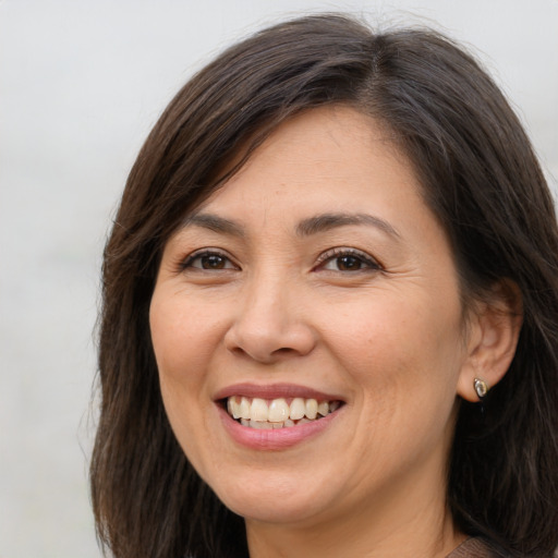 Joyful white adult female with long  brown hair and brown eyes