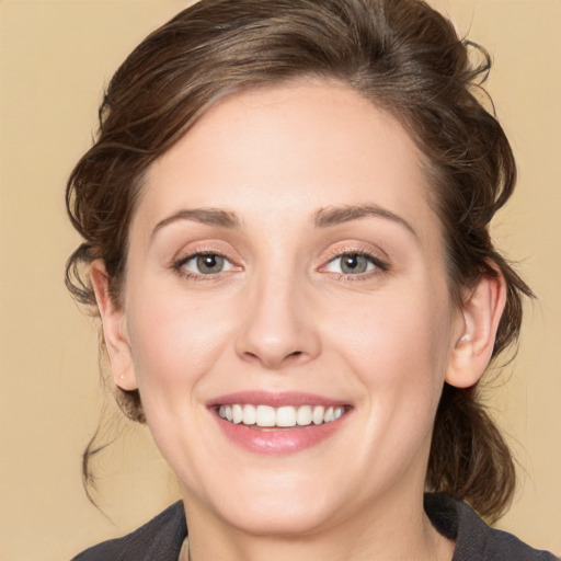 Joyful white young-adult female with medium  brown hair and grey eyes