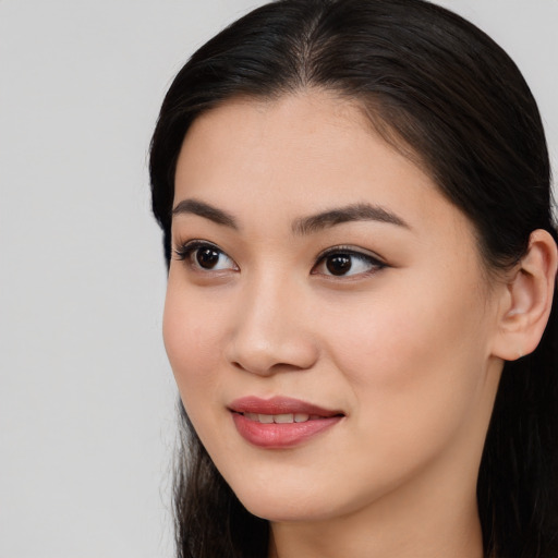 Joyful asian young-adult female with long  brown hair and brown eyes
