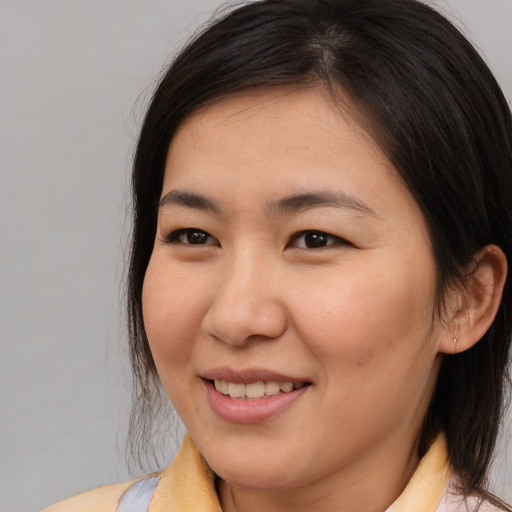 Joyful asian young-adult female with medium  brown hair and brown eyes