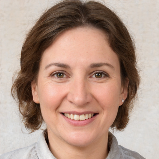 Joyful white adult female with medium  brown hair and brown eyes