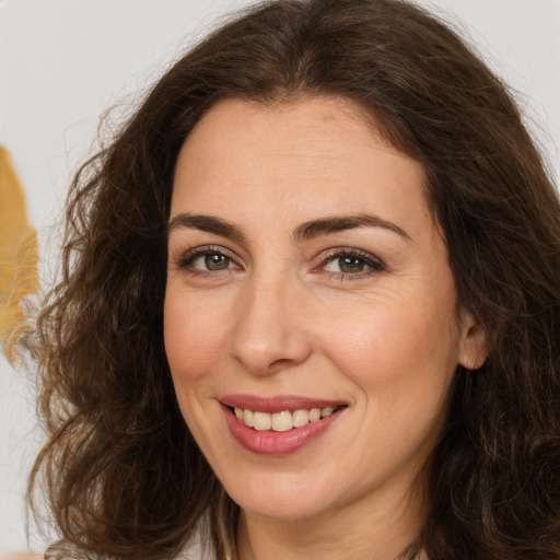 Joyful white adult female with long  brown hair and brown eyes