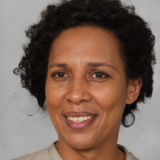 Joyful black adult female with short  brown hair and brown eyes
