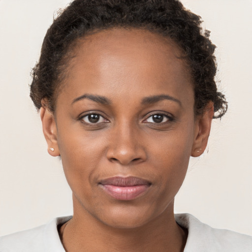 Joyful black young-adult female with short  brown hair and brown eyes