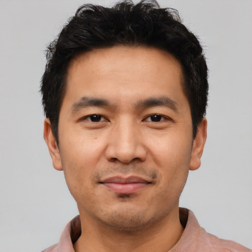 Joyful asian young-adult male with short  black hair and brown eyes
