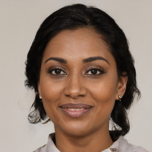 Joyful black adult female with medium  black hair and brown eyes