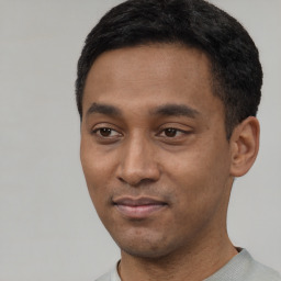 Joyful latino young-adult male with short  black hair and brown eyes