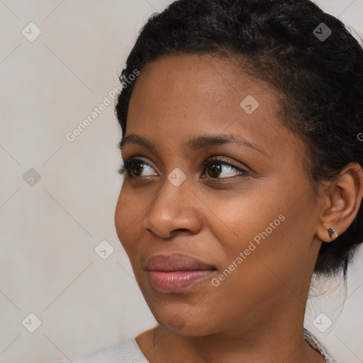 Joyful black young-adult female with short  black hair and brown eyes