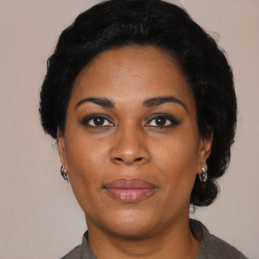 Joyful black young-adult female with short  black hair and brown eyes