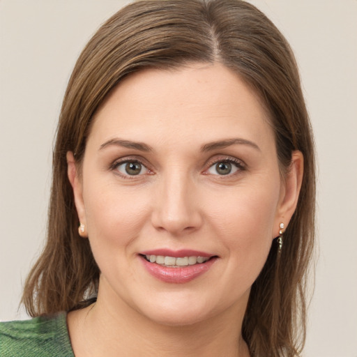 Joyful white young-adult female with medium  brown hair and green eyes