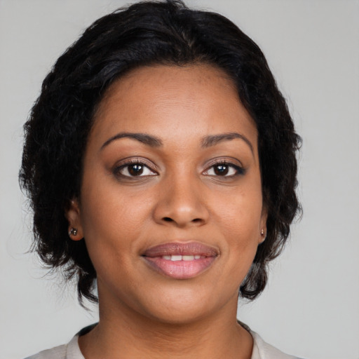 Joyful black adult female with medium  brown hair and brown eyes