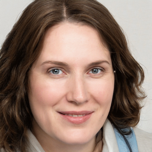 Joyful white young-adult female with medium  brown hair and blue eyes