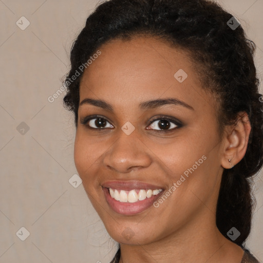 Joyful black young-adult female with long  brown hair and brown eyes