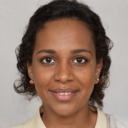 Joyful black adult female with medium  brown hair and brown eyes