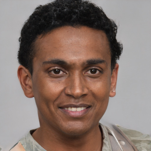 Joyful black young-adult male with short  black hair and brown eyes
