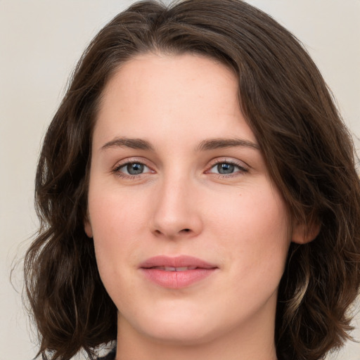 Joyful white young-adult female with long  brown hair and green eyes