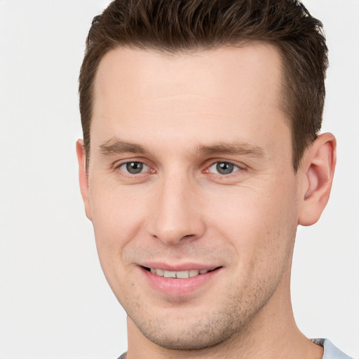 Joyful white young-adult male with short  brown hair and grey eyes