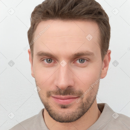 Joyful white young-adult male with short  brown hair and grey eyes