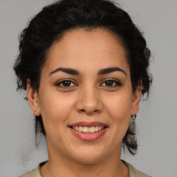 Joyful latino young-adult female with medium  brown hair and brown eyes