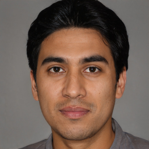 Joyful latino young-adult male with short  black hair and brown eyes