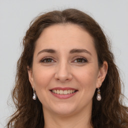 Joyful white young-adult female with long  brown hair and grey eyes