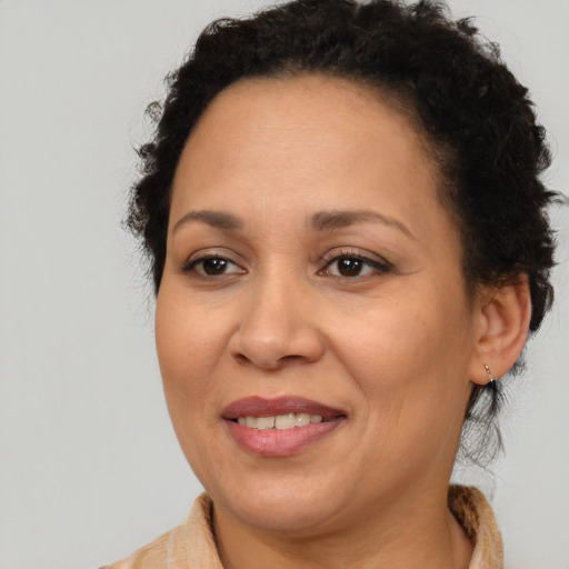 Joyful latino adult female with medium  brown hair and brown eyes