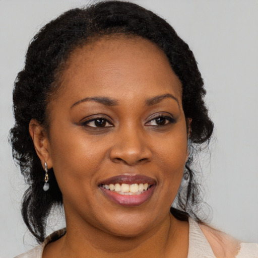 Joyful black young-adult female with medium  black hair and brown eyes