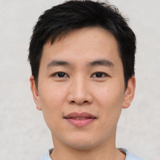 Joyful asian young-adult male with short  black hair and brown eyes