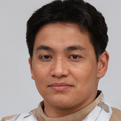Joyful asian young-adult male with short  brown hair and brown eyes