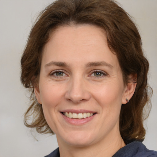 Joyful white adult female with medium  brown hair and grey eyes