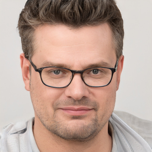 Joyful white adult male with short  brown hair and blue eyes