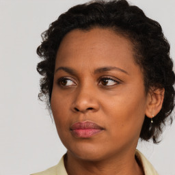 Joyful black young-adult female with medium  brown hair and brown eyes