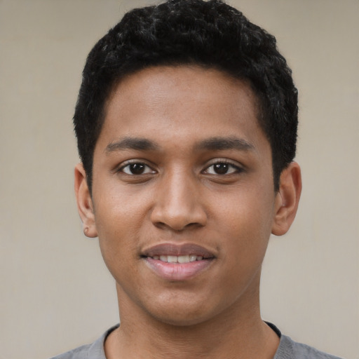 Joyful black young-adult male with short  black hair and brown eyes