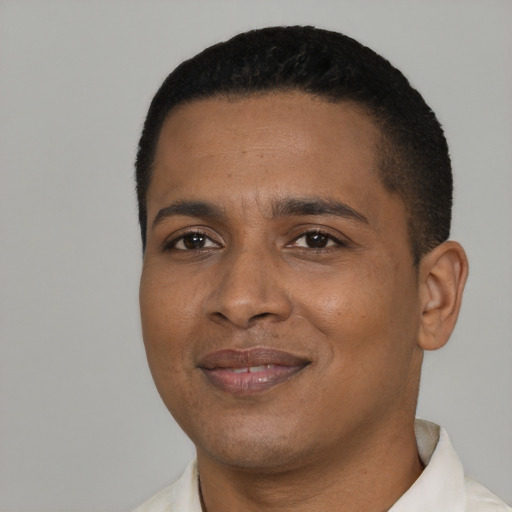 Joyful black young-adult male with short  black hair and brown eyes