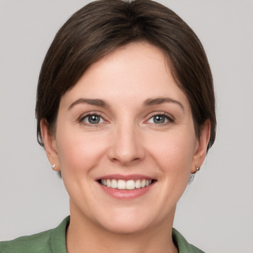 Joyful white young-adult female with short  brown hair and grey eyes