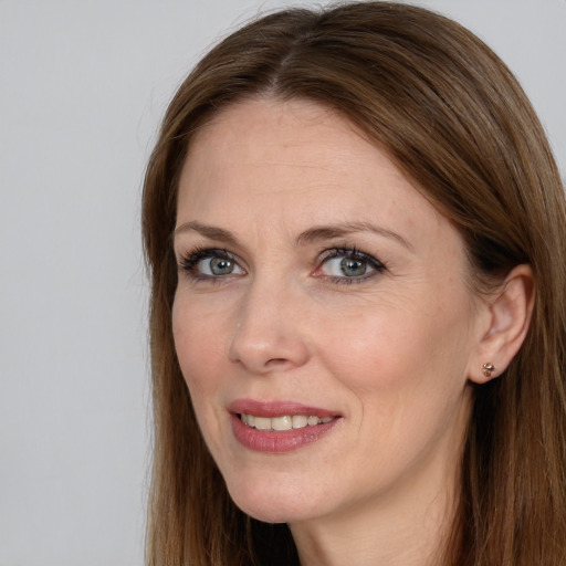 Joyful white adult female with long  brown hair and grey eyes