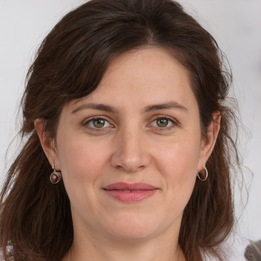 Joyful white adult female with long  brown hair and grey eyes