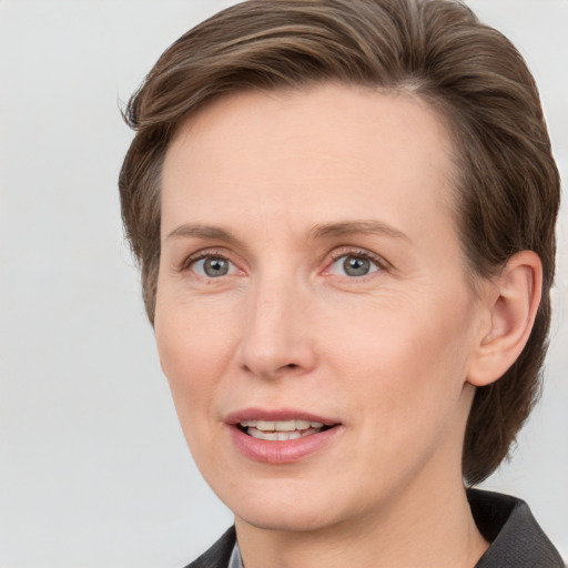 Joyful white adult female with medium  brown hair and grey eyes