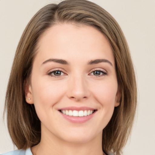 Joyful white young-adult female with medium  brown hair and green eyes