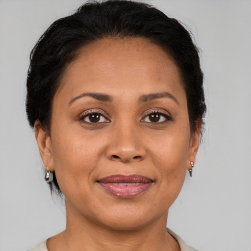 Joyful latino adult female with medium  brown hair and brown eyes