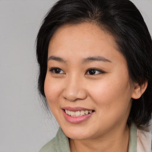 Joyful asian young-adult female with medium  brown hair and brown eyes