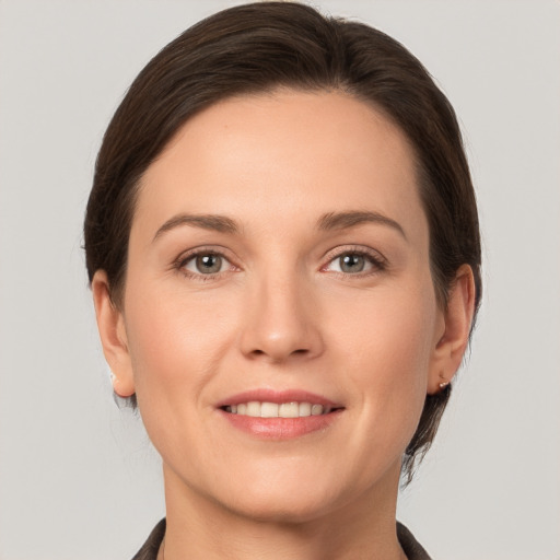 Joyful white young-adult female with medium  brown hair and grey eyes